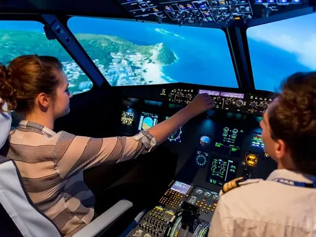 Participante aux commandes d'un simulateur de pilotage d'avion, accompagnée d'un pilote, au parc Team Square